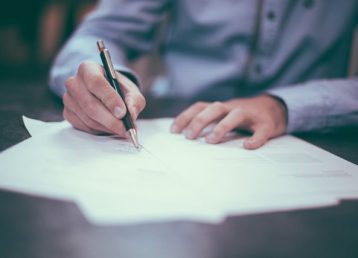 Person in a shirt signing a contract 640