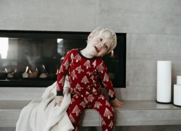 Toddler in pyjamas in front of glass fronted gas fire 640