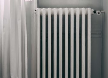 White radiator next to a white curtain 640